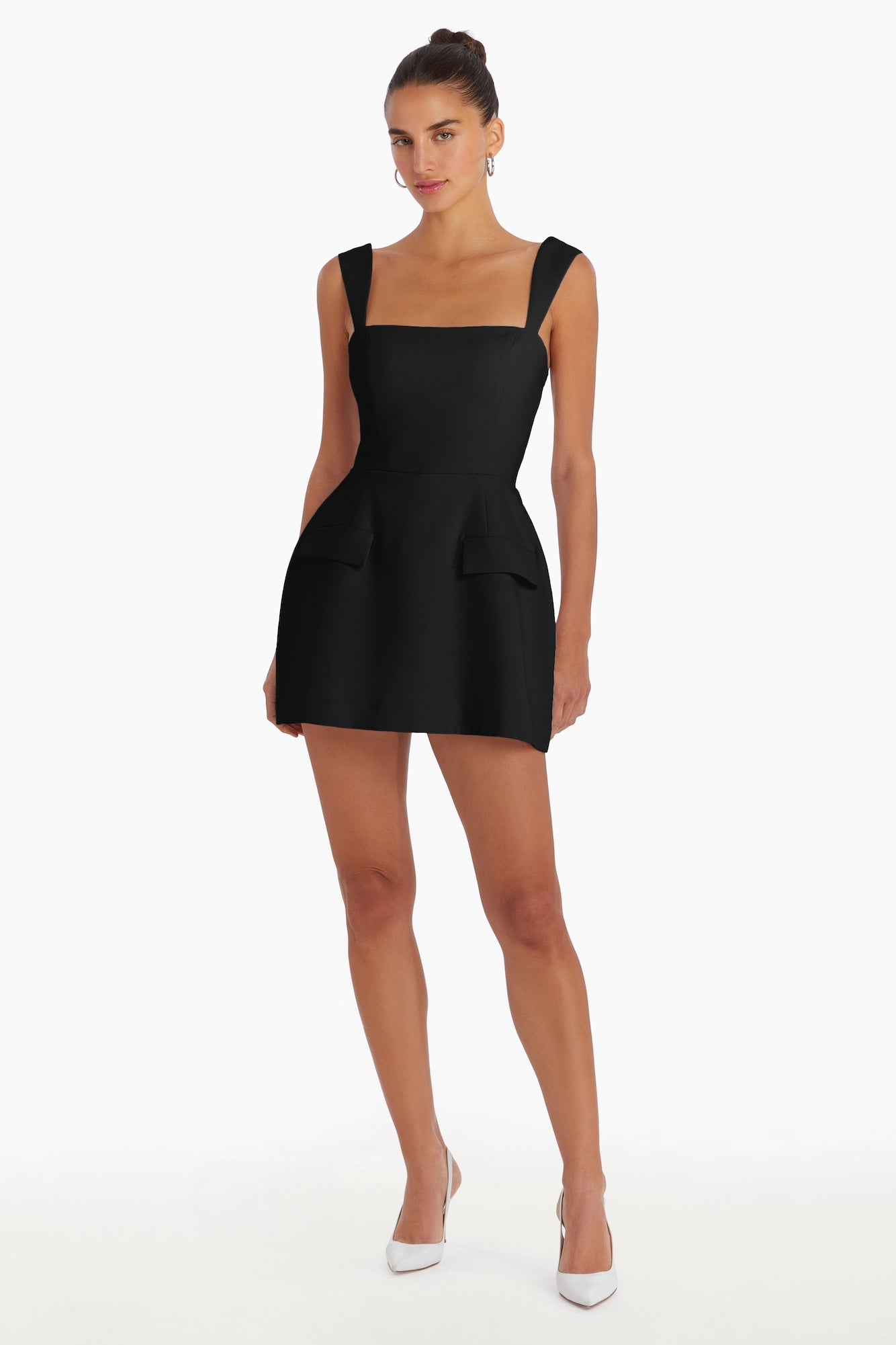 Girl in black romper dress, front facing.